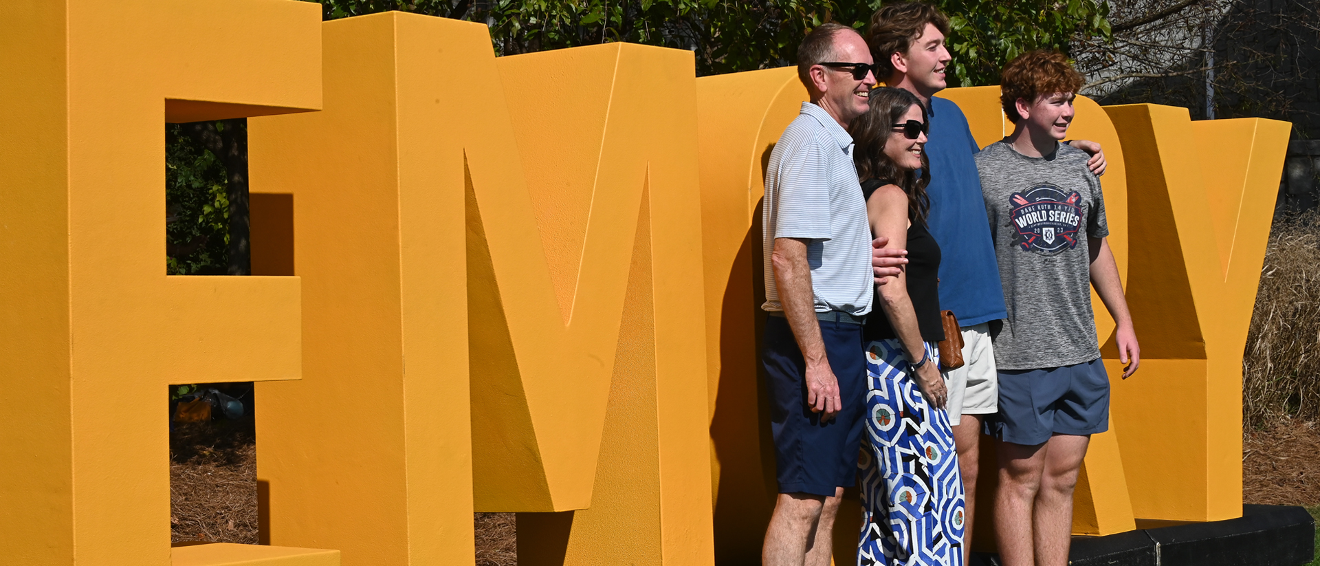 family standing in front of the giant EMORY letters for a homecoming event