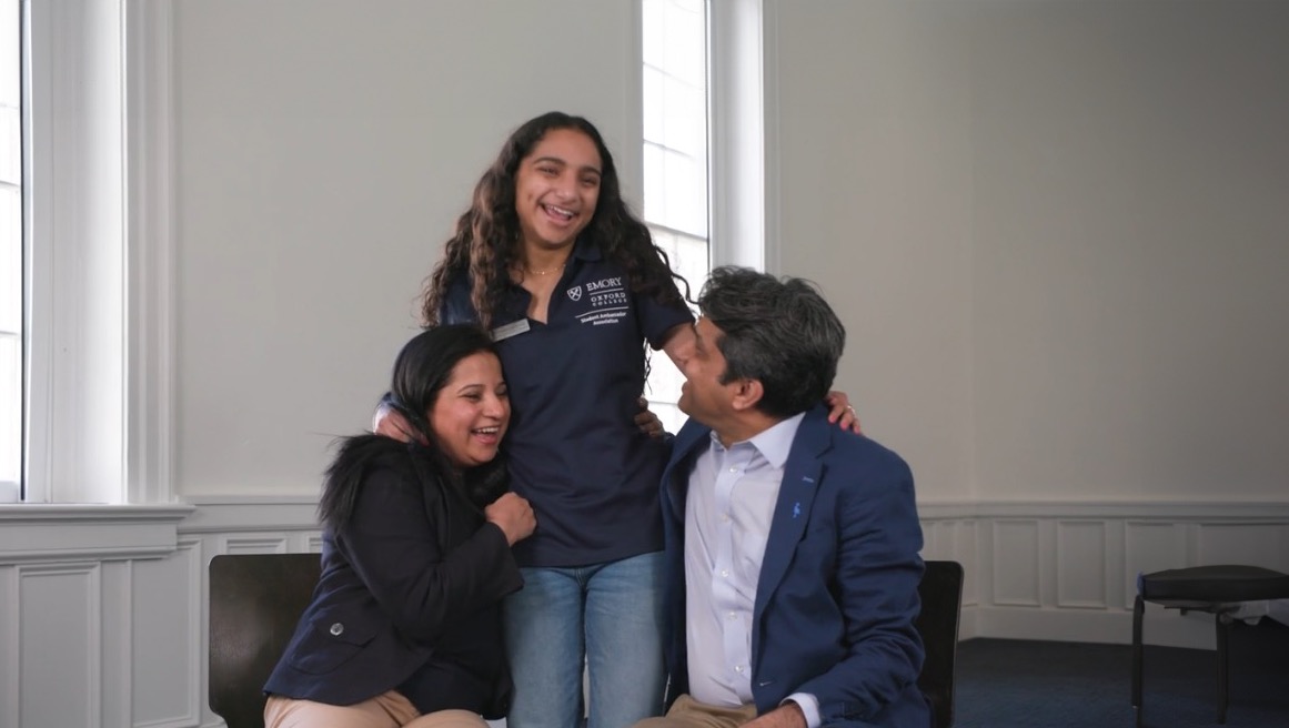 a student stands with her parents