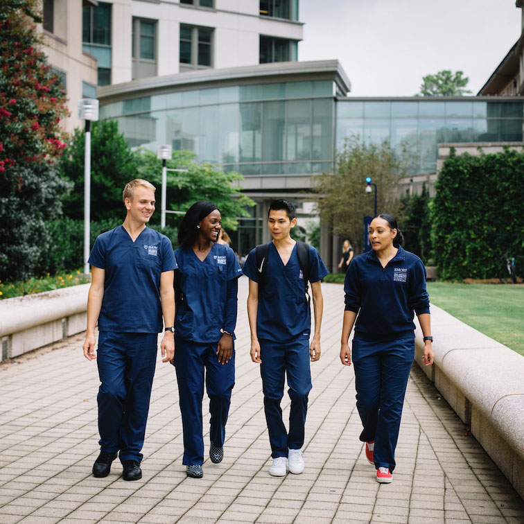 School of Nursing students walking in front of their school